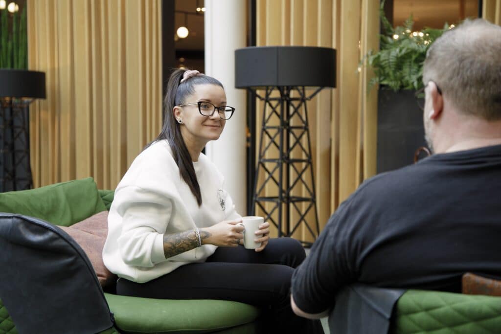 Bilde som viser to personer som snakker med hverandre i en sofa. Kan illustrere likepersoner, ny med ms, samtale.