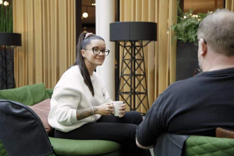 Bilde som viser to personer som snakker med hverandre i en sofa. Kan illustrere likepersoner, ny med ms, samtale.
