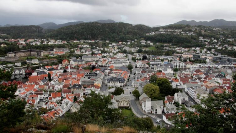Oversikt over Flekkefjord med fjell i bakgrunnen.