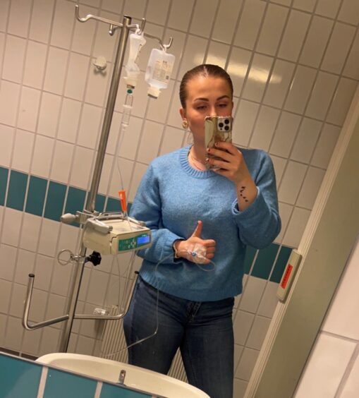 Bilde av Helle Øyan Borsodi som poserer med intravenøs behandling på rehabilitering.