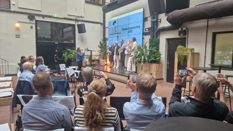 Forskere på scenen som mottar blomster og diplom under forskingstildelingen 2025